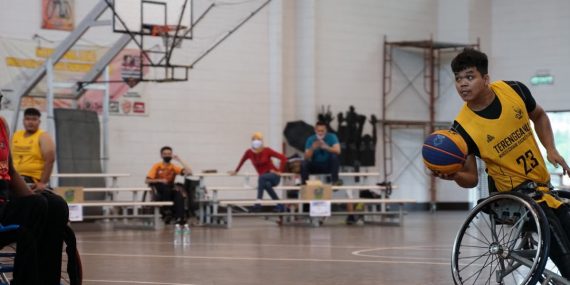 Dynamic wheelchair basketball game showcasing skill and determination indoors.